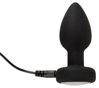 LED Buttplug med Vibration, en svart analplugg i silikon med rundad spets och ansluten laddningskabel, visas på en vit bakgrund.