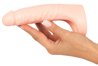 En hand som håller en Double Fucker Med Vibration, en kötttonad, texturerad dildo designad för dubbel penetration.