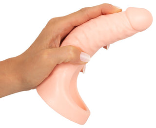En hand håller Double Fucker Med Vibration, en kötttonad texturerad silikon dildo med en böjd bas, perfekt för en äventyrlig dubbel penetrationsupplevelse.
