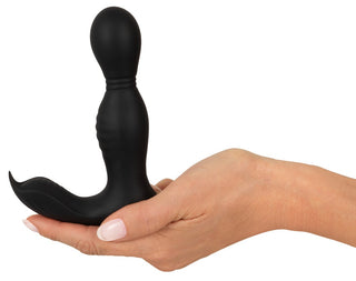 En hand håller RC Buttplug 2 Funktioner, en elegant svart silikon dubbelmotorisk analvibrator designad för prostatastimulering, mot en skarp vit bakgrund.