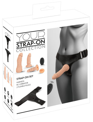Låda som visar Strap-on Set med Vibrator, med realistiska dildos och en fjärrstyrd vibrator, visad på en gråskalefigur.