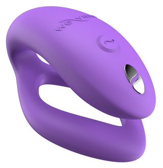 Den lila WE-Vibe Sync O Vibrator, tillverkad av silikon med en böjd design och två överlappande öglor, har en knapp och metallic accent. Den ansluts sömlöst till We-Vibe-appen för förbättrad kontroll.