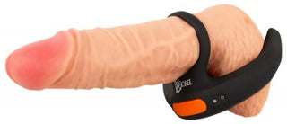 Vibrerande Scrotumstimulator Rebel är en mångsidig bärbar enhet med en ringdesign på en realistisk fallisk replika, med en logotyp och knappar, som också fungerar som en effektiv cockring.