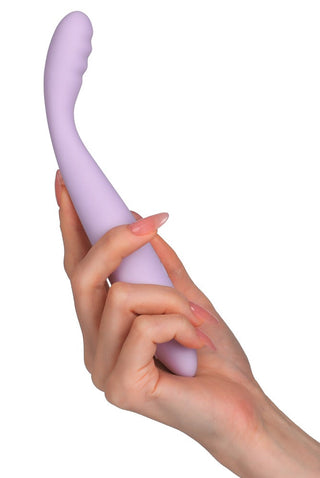 En persons hand håller Svakom Cici 2 Vibrator mot en vit bakgrund och visar upp dess lila, böjda design med en texturerad spets. Vibratorn har en slät yta och ergonomisk design som erbjuder flexibel användning.