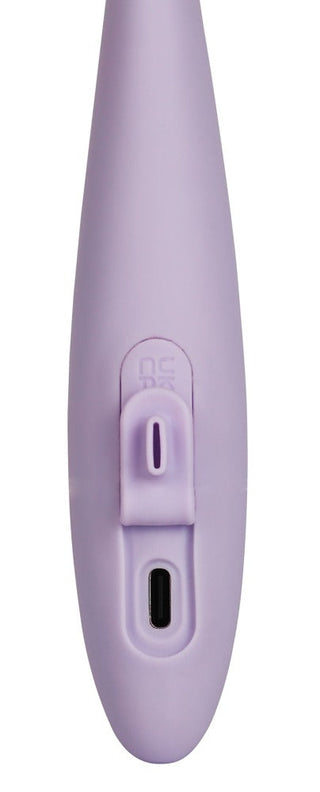 En närbild av Svakom Cici 2 Vibrators lavendelfärgade handtag visar ett centralt spår som inrymmer strömbrytaren för enkel åtkomst, tillsammans med en liten rektangulär laddningsport under den, allt på en slät yta.