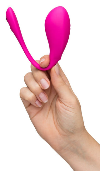 En hand håller WeVibe Jive 2, en rosa, ergonomisk bärbar massageapparat designad för komfort och kontroll, mot en vit bakgrund.