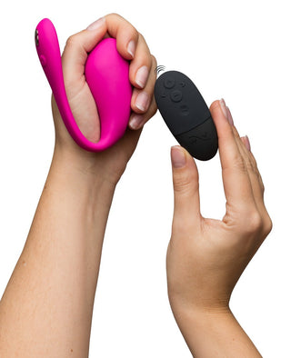 Händer som håller WeVibe Jive 2 bredvid den svarta fjärrkontrollen mot en vit bakgrund.
