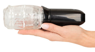 En hand håller Masturbator med 360° Massage, en svart och transparent roterande penismassagerare, mot en vit bakgrund.