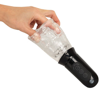 En hand håller Masturbator med 360° Massage, en svart och transparent elektronisk apparat med kontrollknappar, avsedd för roterande penismassage.