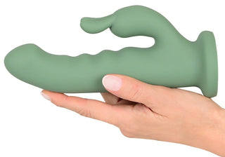 En hand håller i LUVIO Soft Rotating Rabbitvibrator, tillverkad av mjuk silikon med ett texturerat skaft och ett böjt fäste för dubbel stimulering.