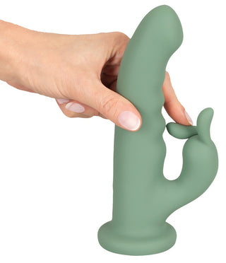 En hand som håller i LUVIO Soft Rotating Rabbitvibrator, tillverkad av mjuk silikon med en böjd design och robust bas.