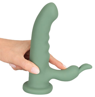 En hand håller LUVIO Soft Rotating Rabbitvibrator, tillverkad av mjuk silikon, med ett grönt böjt huvudskaft och en mindre förlängning för dubbel stimulering.