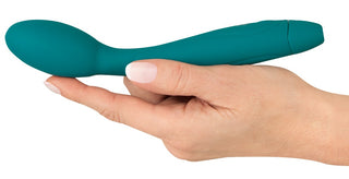 En hand håller i Vibratorn med Nickande Huvud, en blågrön, böjd silikonvibrator avsedd för stimulering av G-punkten, mot en vit bakgrund.