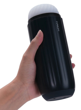 En hand håller ett svart cylindriskt föremål med ett texturerat grepp, med en vit keps och varumärket SVAKOM. Enheten, Svakom Sam Neo 2 Pro, förstärkt av SVAKOM-appen, erbjuder spännande interaktiva möjligheter för användare.