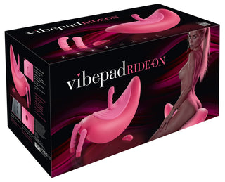 Box för Vibepad RIDE ON, en handsfree-stimulator avsedd för klitorisstimulering, med produkten och en kvinna som poserar mot en mörk, vågig bakgrund.