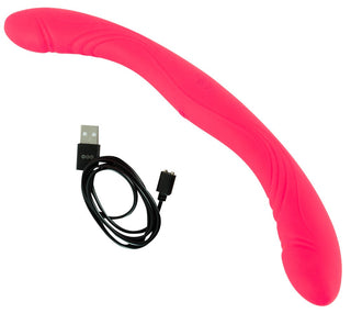 En Couples Choice Double Vibrator i rosa silikon med kurvad design och USB-laddningskabel bredvid, på en vit bakgrund.