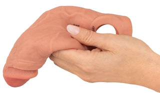 En hand som håller i Vibro Sleeve med Ballring, en realistiskt utseende, köttfärgad penishylsdildo med en ring vid basen.