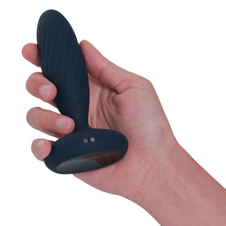 En hand håller en svart SVAKOM Jordan Buttplug, en vattenbaserad analvibrator med SVAKOM Intelligent Mode, mot en vit bakgrund.