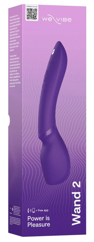 We-Vibe Wand 2-förpackningen har den eleganta produktbilden med "Wand 2"-text, som betonar Smart Silence-teknik, massagestavsfunktioner, en QR-kod, kompatibilitetsikoner och sloganen "Power is Pleasure", allt mot en vågig linjedesign.