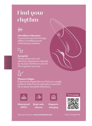 Dunkelrosa förpackning för Womanizer Vibe Klitorisvibrator, som framhäver dess vibrationsfunktioner, UltraWave-teknologi och en QR-kod.