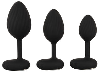 Tre ANOS RC Buttplug Set i svart silikon, olika storlekar, står sida vid sida på vit bakgrund - perfekt för dig som vill utforska nya nivåer av stimulans och hitta rätt vibrationsset.