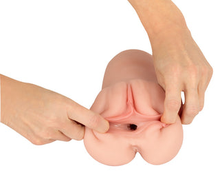En person som håller i Realistixxx RealMasturbator Lösvagina, tillverkad av realistiskt Natureskin-material.
