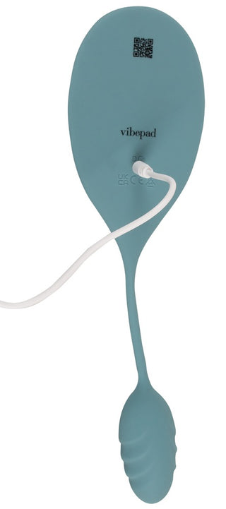Sittvibratorn Vibepad Mini i blågrön silikon visas bakifrån med medföljande laddningskabel och synligt varumärke.