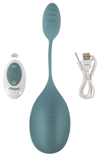 Sittvibrator i blå silikon med konturerad design, fjärrkontroll och USB-laddningsport visas.