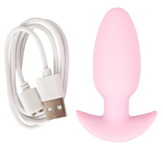 En rosa Cuties Mini Vibrating Plug för analplugg nybörjare ligger bredvid en vit USB-laddningskabel på en vit bakgrund.