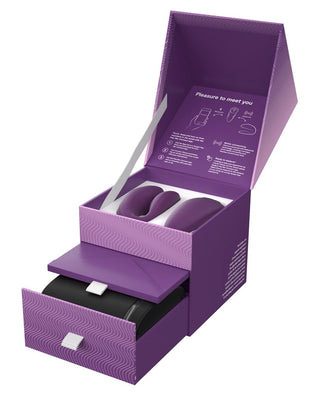 Lila låda med två böjda lila enheter, en nedre låda och instruktioner för locket - perfekt för förvaring av din We-Vibe Chorus Parvibrator eller någon annan fjärrstyrd sexleksak.