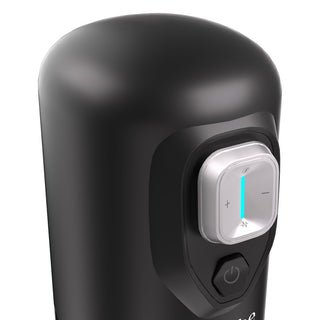 Närbild av IKON SPARK Masturbator i svart med en silverfärgad ratt och blått ljus, som visar plus- och minussymboler för att justera roterande trycklägen under penismassage.