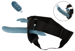 Blå strap-on med en vibrerande kaninvibrator, svart justerbar sele och handhållen fjärrkontroll; vibrationsinställningarna visas i infälld bild.