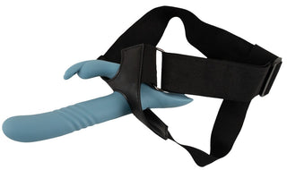 Blå strap-on-vibrator i form av en stötande kanin med svart sel och strukturerad skaft, avbildad mot en vit bakgrund.