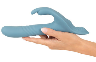 Strap-On med Thrusting Rabbit-vibrator, tillverkad av silikon, rosa, i kanindesign, avbildad mot en vit bakgrund.