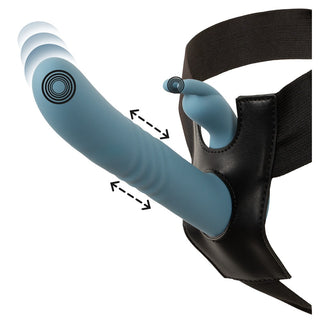 Blå strap-on med en vibrerande kaninvibrator och vibrationsindikatorer, fäst vid en svart sele i konstläder.