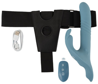 En strap-on-vibrator i kaninmodell med fram- och återgående rörelser, sel, fjärrkontroll och USB-laddningskabel, avbildad mot en vit bakgrund.
