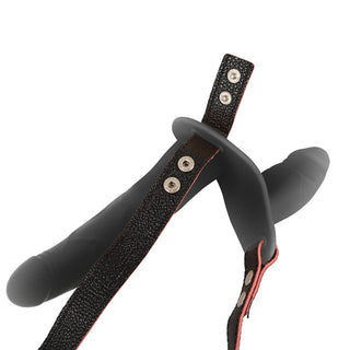 Svart, justerbar strap-on-sele med dubbla remmar och två fästpunkter, tillverkad av slätt material.