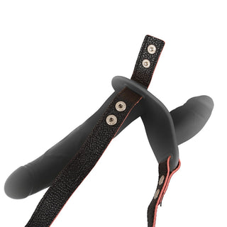 Svart, justerbar strap-on-sele med dubbla remmar och två fästpunkter, tillverkad av slätt material.