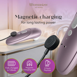 Womanizer Pro Klitorisstimulator i lila silikon med smidig, ergonomisk design som laddas på nattduksbordet.