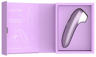 Lila och silver Womanizer Pro klitorisstimulator med slät yta, visas i en öppen låda.