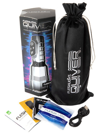 Fleshlight Quiver masturbator i svart silikon med texturerat fodral, USB-kabel och glidmedelsprov; förpackningen visas i bakgrunden.