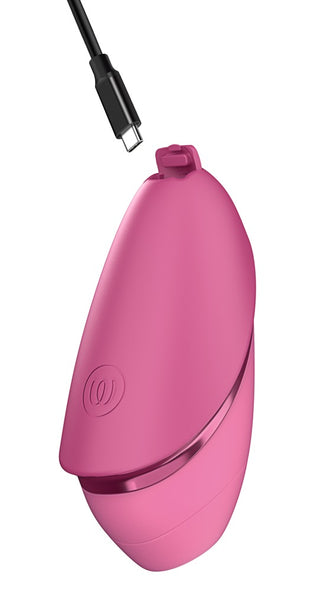 Rosa Womanizer Next Liberty 3D Lufttryck, tillverkad i silikon, med strömsymbol; svart USB-C-kabel ovanför den.