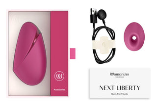 Rosa silikonmodell av Womanizer Next Liberty 3D Lufttryck med USB-laddare och bruksanvisning mot vit bakgrund.