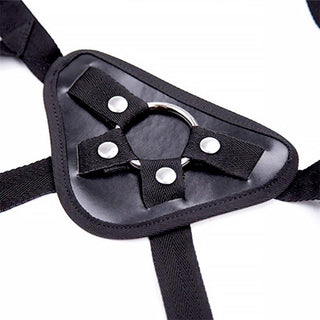 Justerbar Strap-On-selen har justerbara svarta remmar och en robust metallring, allt mot en skarp vit bakgrund.