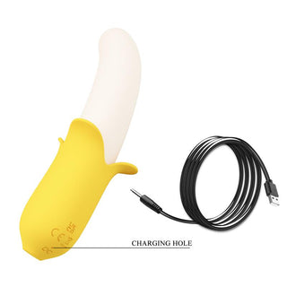 Bananformad vibrator i gul silikon med svart USB-laddningskabel och tydligt markerad laddningsport.