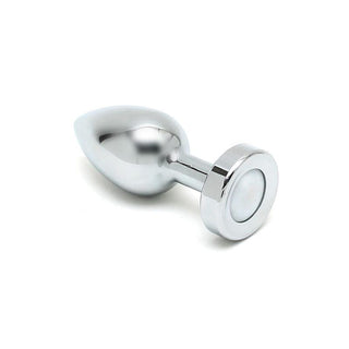 Rimba Buttplug Med LED, en elegant och glänsande silvermetallenhet med en avsmalnande ände och cirkulär bas, vilar på en vit yta. Den är smidig och idealisk för äventyr i temperaturlek.