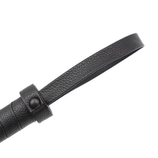 En närbild av Latetobed Classic Flogger 42cm visar dess svarta texturerade läderrem, den knappförsedda öglan och den eleganta designen.
