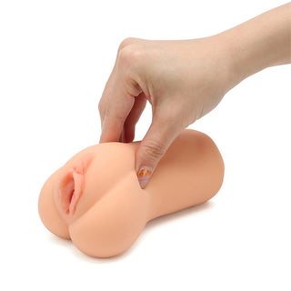En hand som håller och klämmer på Realistisk Vaginamasturbator 13 cm, tillverkad av mjuk TPE för extra stimulans och en verklighetstrogen upplevelse.