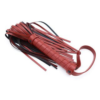 Mjuk Flogger Piska 40 cm, med sin premiumkänsla, visar upp flera svarta och röda svansar elegant utspridda över en vit yta.
