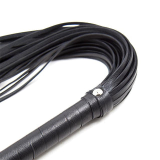 Latetobed BDSM Flogger 69 cm är tillverkad av svart läder med flera svansar och ett omlindat handtag med metalldetaljer, som visas på en vit bakgrund.